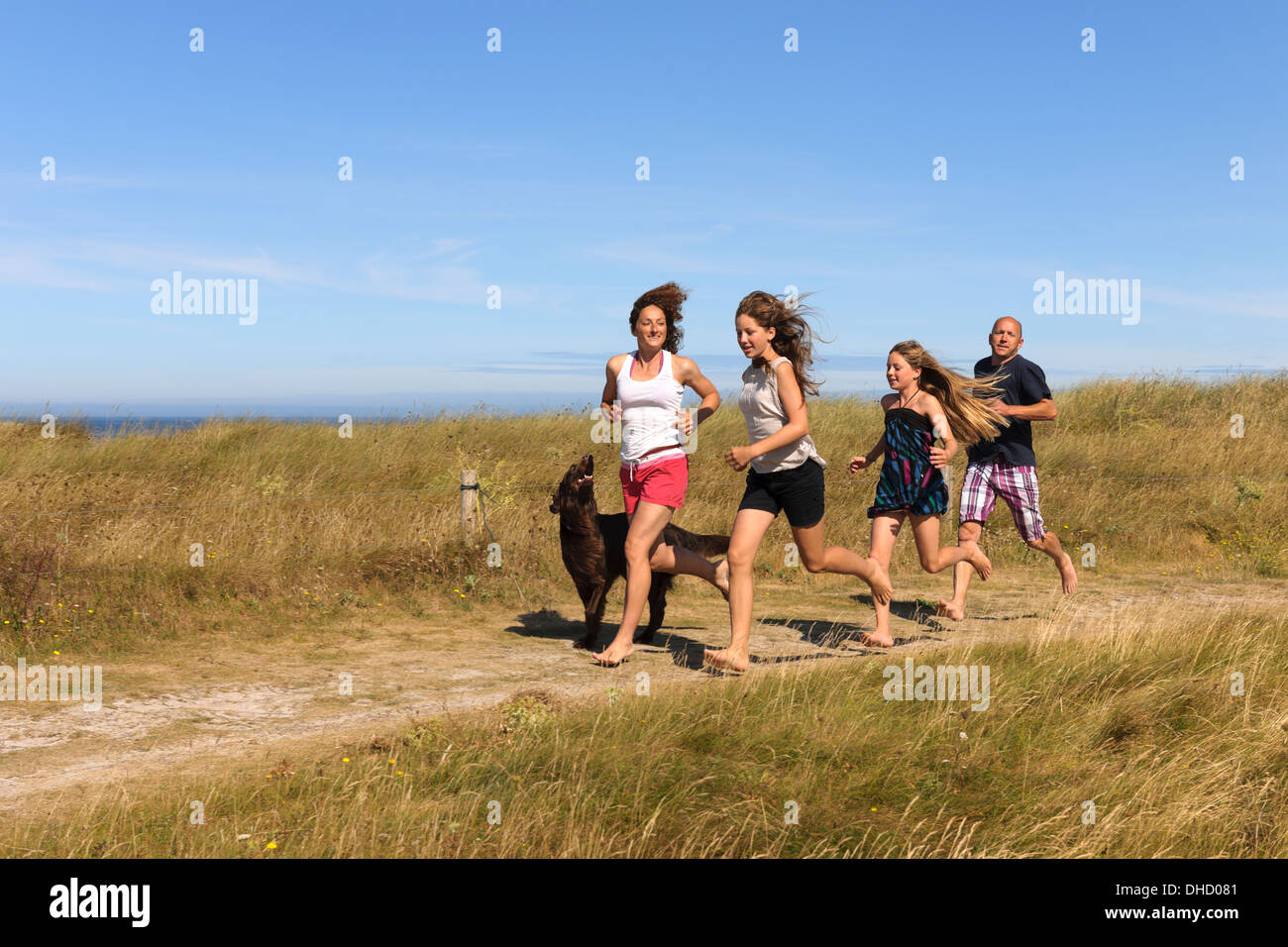 Frankreich, Bretagne, Ste-Marguerite, Landeda, Finistere, Eltern und zwei Töchtern auf einer Düne am Atlantik mit ihrem Hund ausgeführt Stockfoto