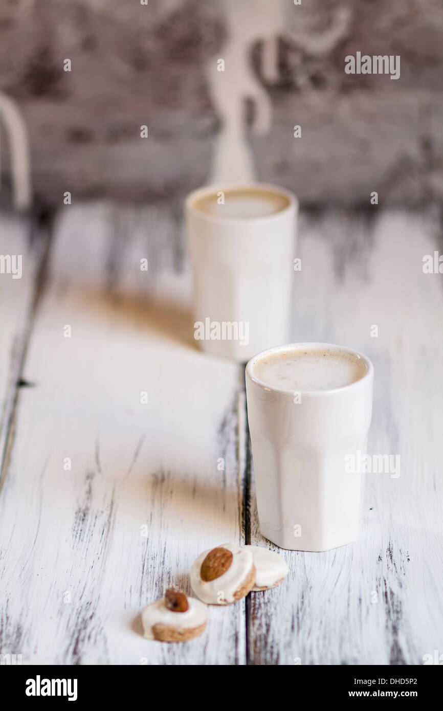 Tassen Latte Macchiatto mit Mandel Kekse auf Holzbrett Stockfoto