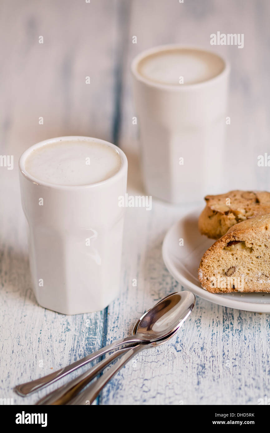 Tassen Latte Macchiatto mit Mandel Kekse auf Holzbrett Stockfoto