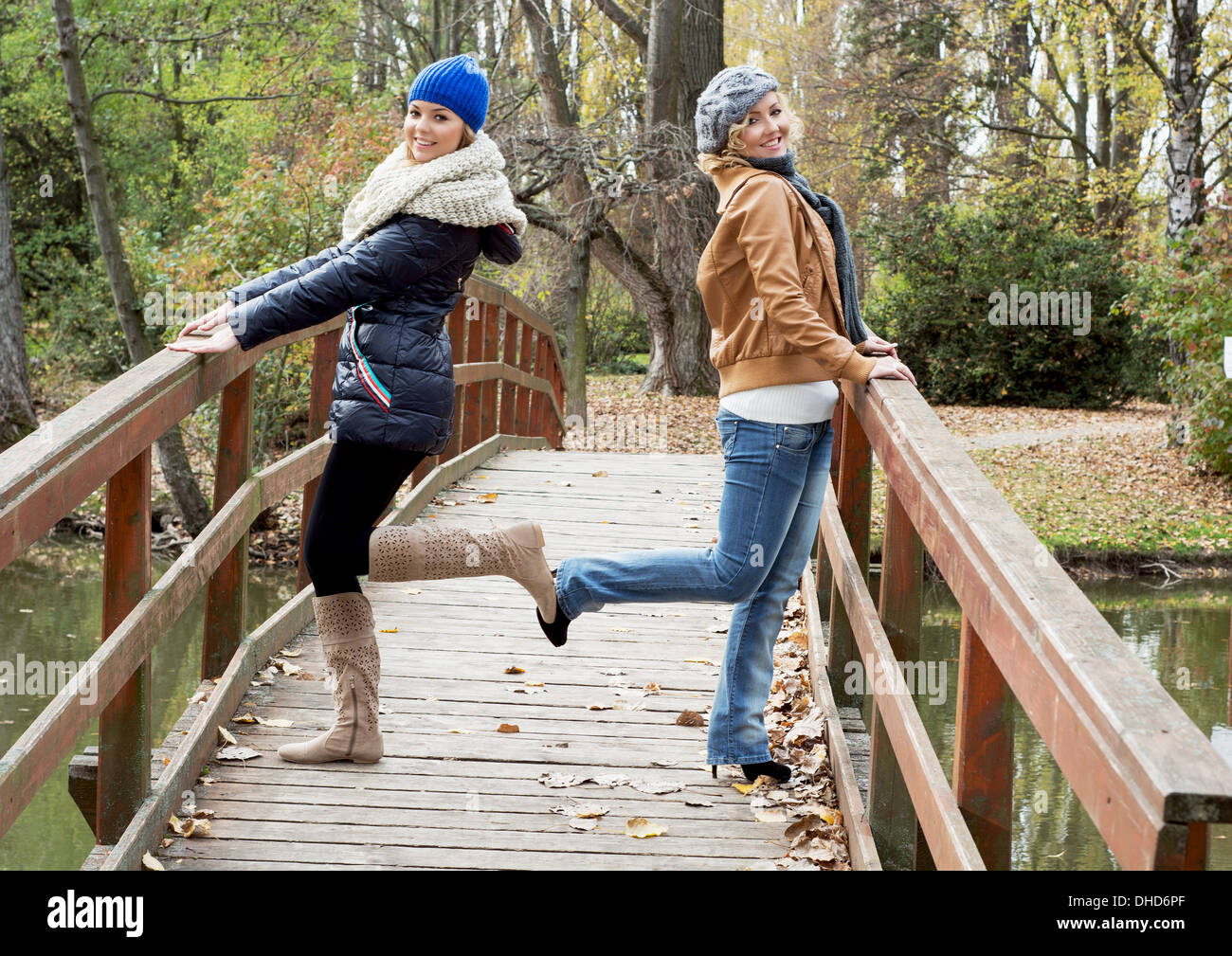 Zwei attraktive kaukasischen Frauen posieren auf einer Holzbrücke im Herbst Park. Stockfoto
