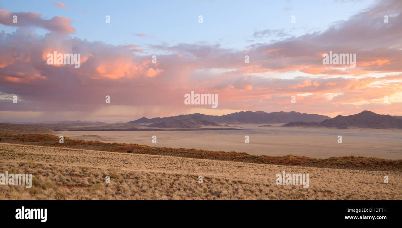 Einige dringend benötigte Regen fällt in der Ferne in der Abenddämmerung im NamibRand Nature Reserve, Namib-Wüste, Namibia, Afrika Stockfoto