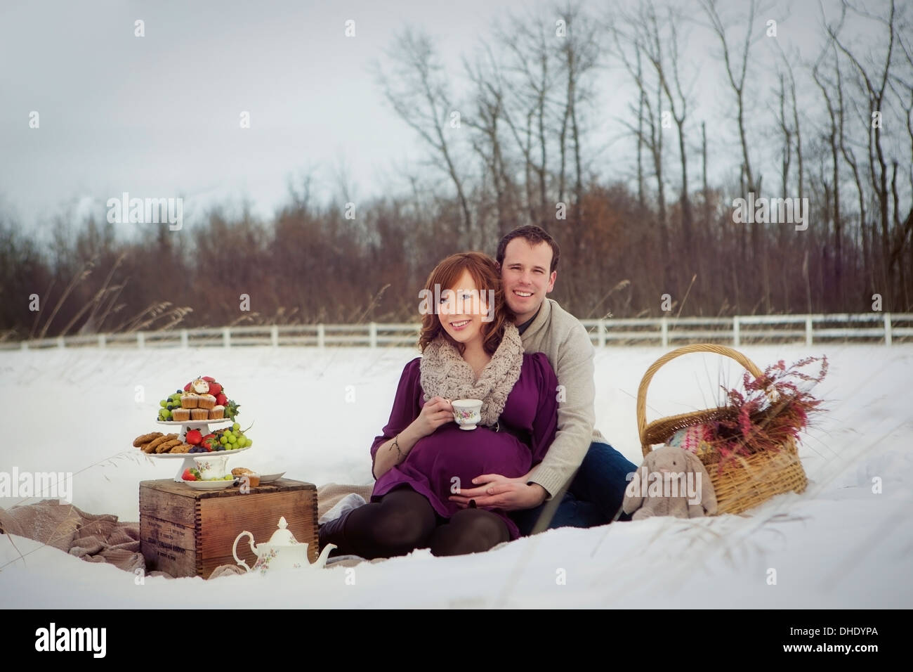 Ein paar mit einem Winter-Picknick während der Schwangerschaft; Edmonton, Alberta, Kanada Stockfoto