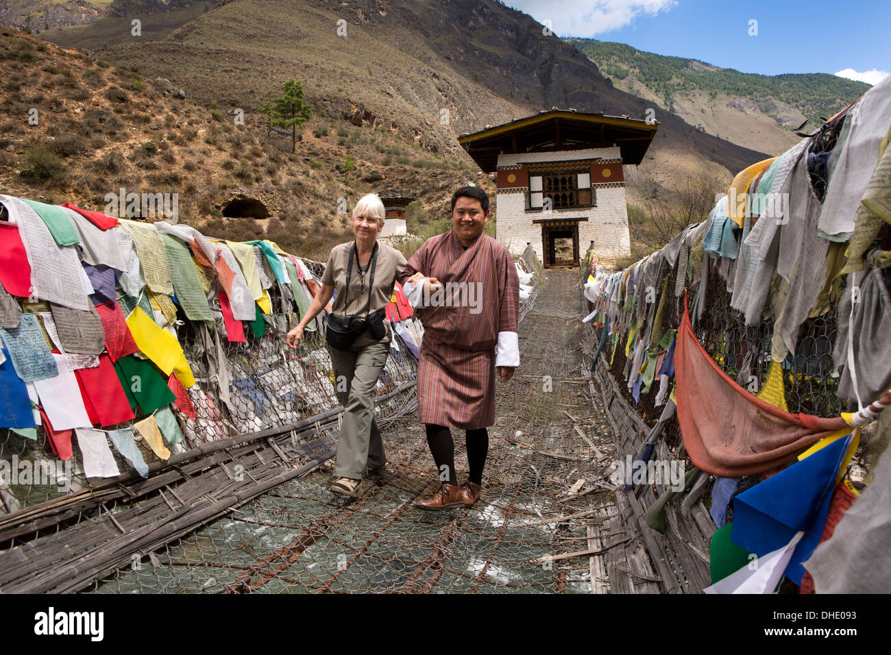 Bhutan, Paro-Tal, weibliche Touristen half über Tachog Lhakang Dzong Brücke, vom guide Stockfoto