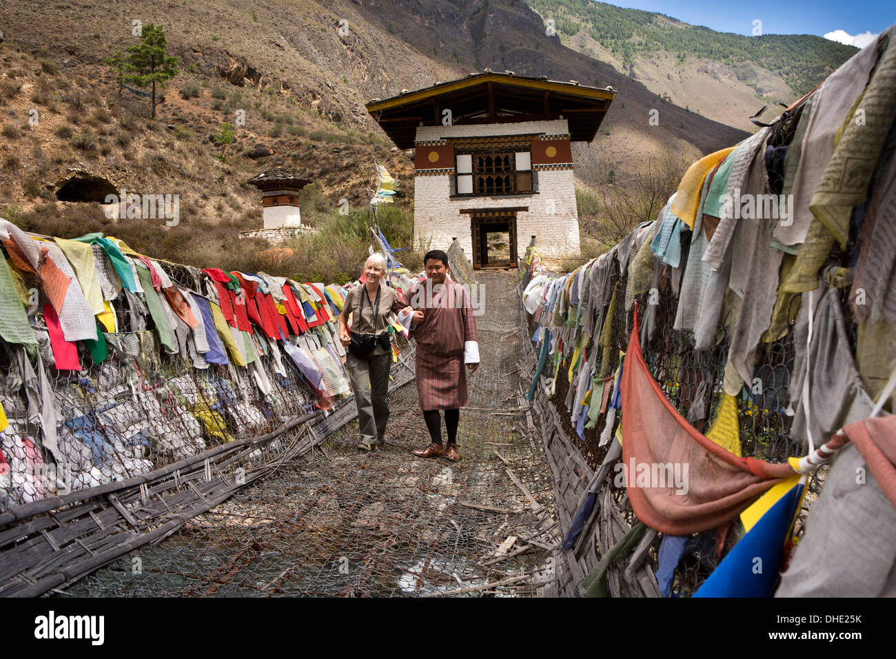 Bhutan, Paro-Tal, weibliche Touristen half über Tachog Lhakang Dzong Brücke, vom guide Stockfoto