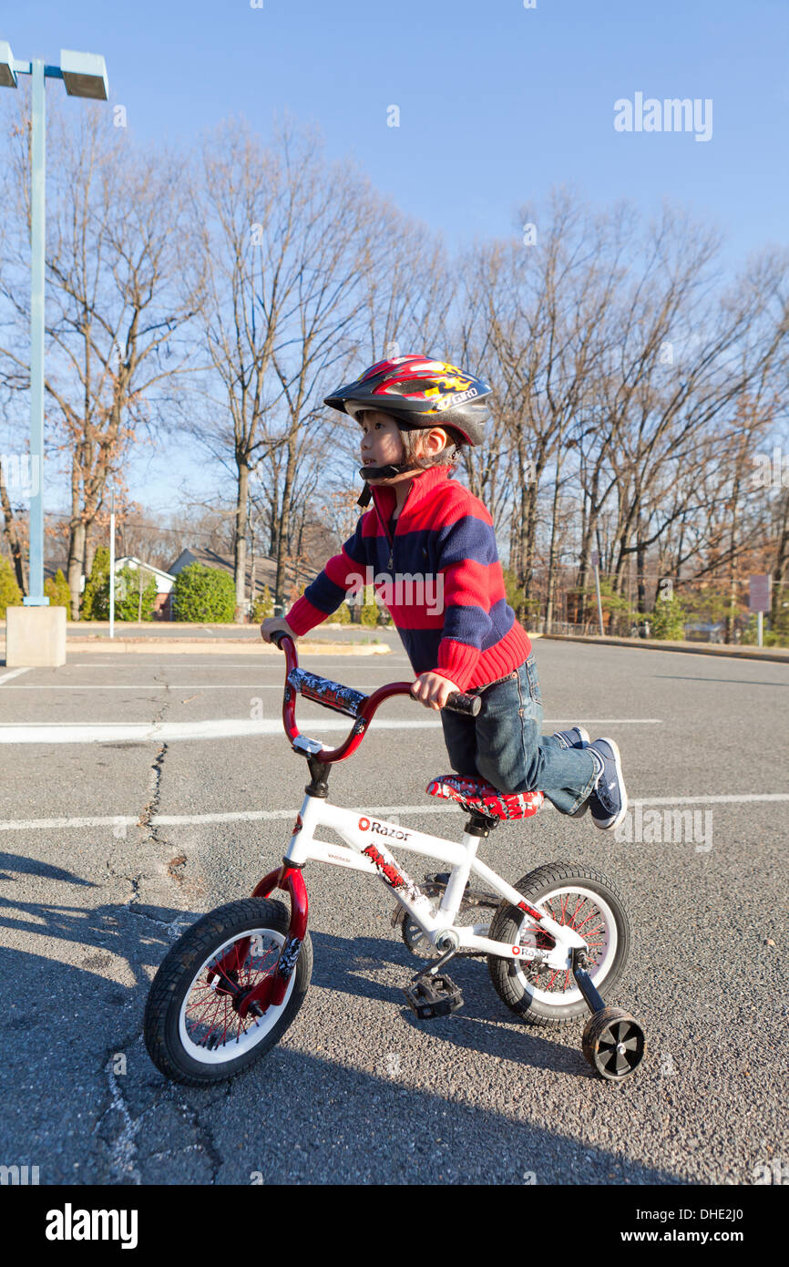 Asiatische junge 3 Jahre alt, Fahrrad mit Stützräder Stockfoto