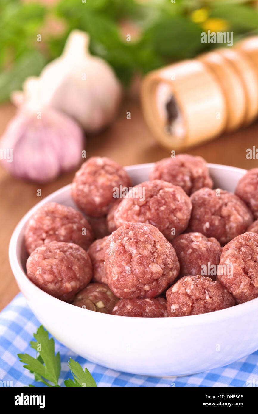 Rohe Frikadellen mit Knoblauch in einer weißen Schüssel (selektiven Fokus, Fokus auf die Frikadellen in der Front) Stockfoto