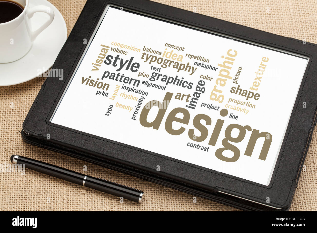 Wolke aus Worten oder Tags, die im Zusammenhang mit Grafik-Design auf einem digitalen Tablet mit einer Tasse Kaffee Stockfoto