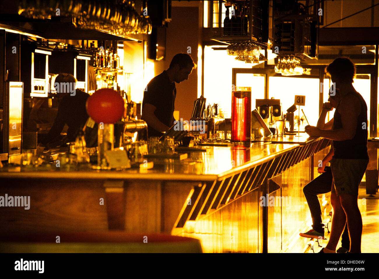 Mitarbeiter und Förderer einer Glenelg Bar (in Adelaide) Silhouette gegen den Sonnenuntergang. Stockfoto
