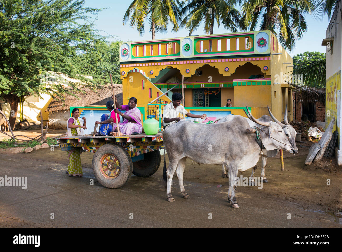 Südindische Menschen auf einem Ochsenkarren vor einem indischen Dorf-Haus. Andhra Pradesh, Indien Stockfoto