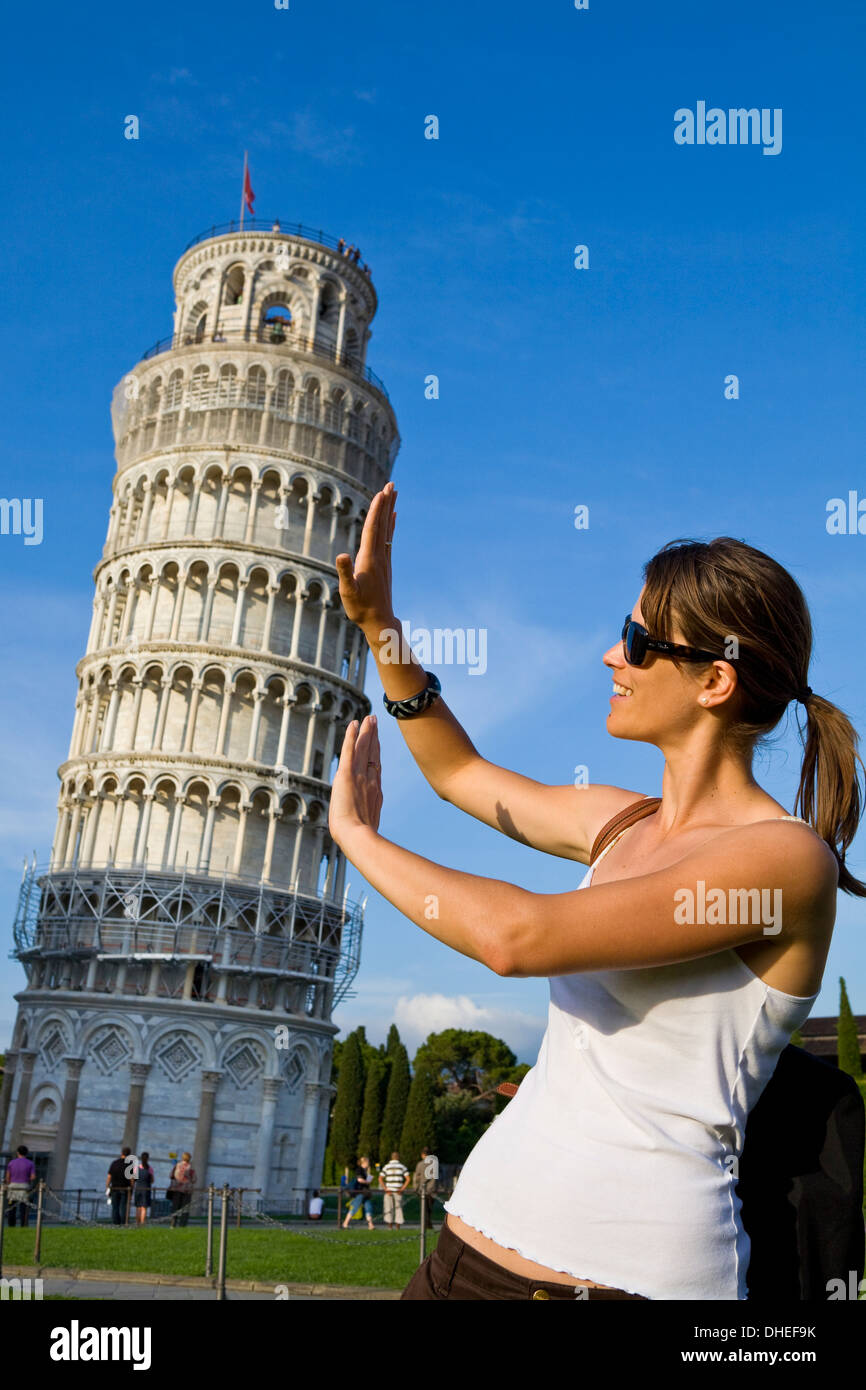 Junge Frau posiert für Fotos mit dem schiefen Turm von Pisa, Pisa, UNESCO World Heritage Site, Toskana, Italien, Europa Stockfoto