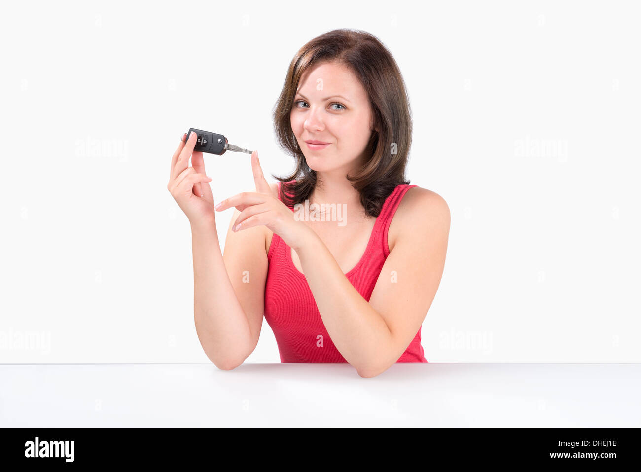 Glückliche junge Frau Autoschlüssel in ihren Händen hält und in die Kamera schaut Stockfoto