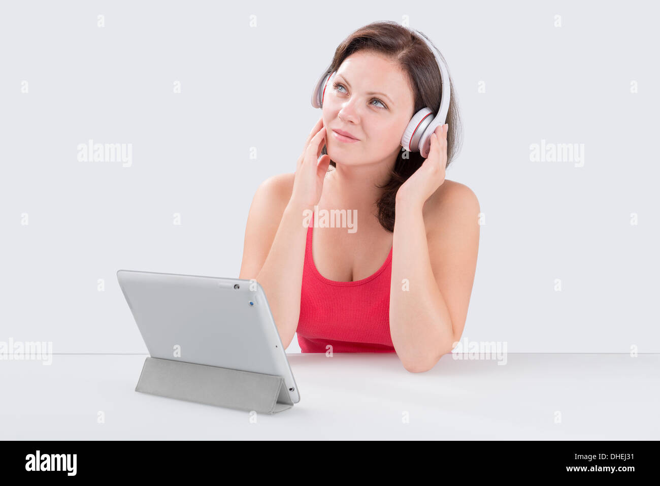 Junge Frau hört Musik über Bluetooth-Kopfhörer von digital-Tablette Stockfoto
