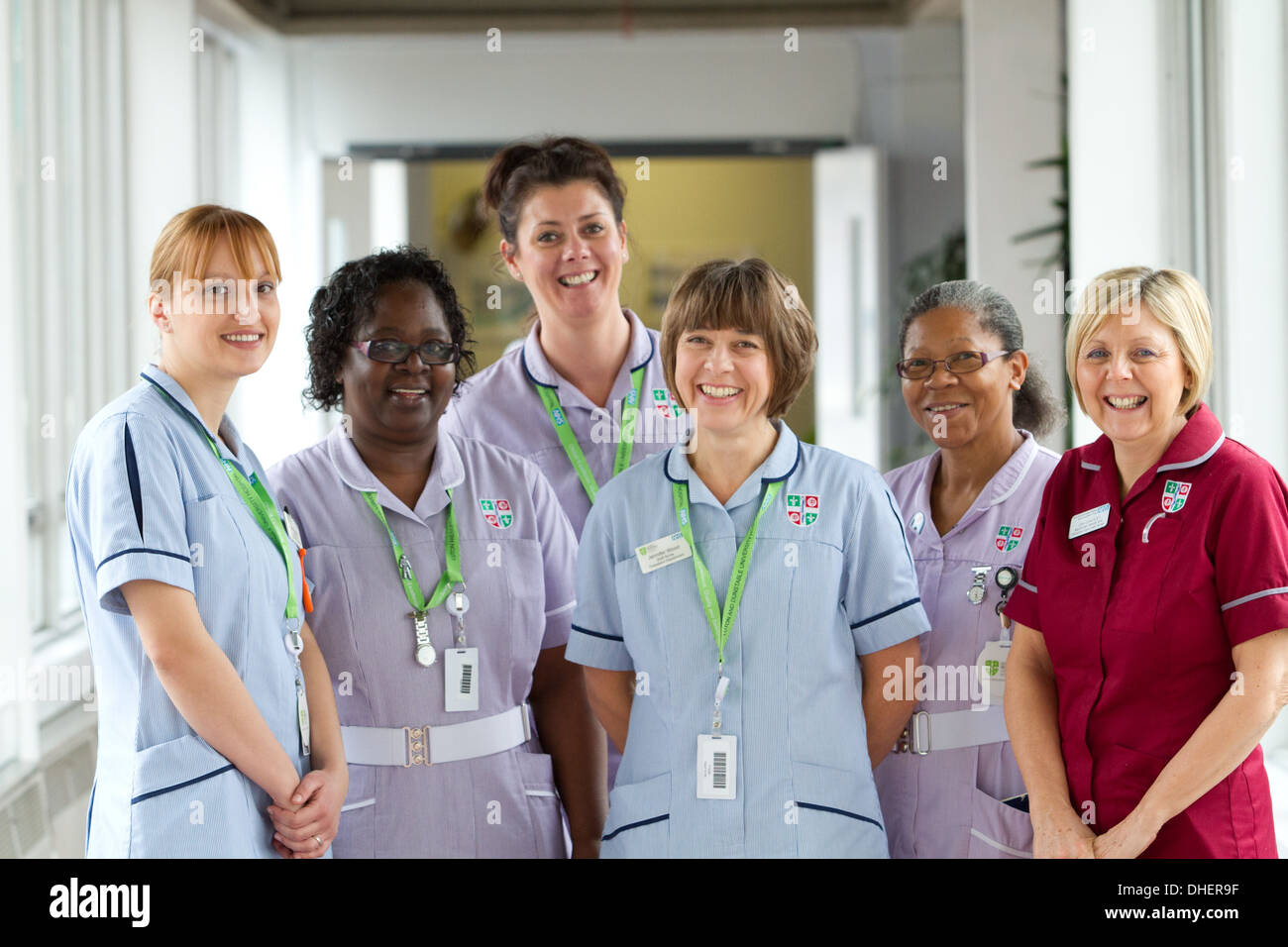 Eine Gruppe von 5 Krankenschwestern Lächeln in Richtung der Kamera in einem Krankenhausflur UK Stockfoto