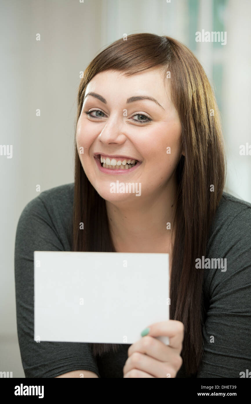 Glückliche junge Frau mit einer leeren Karte Stockfoto