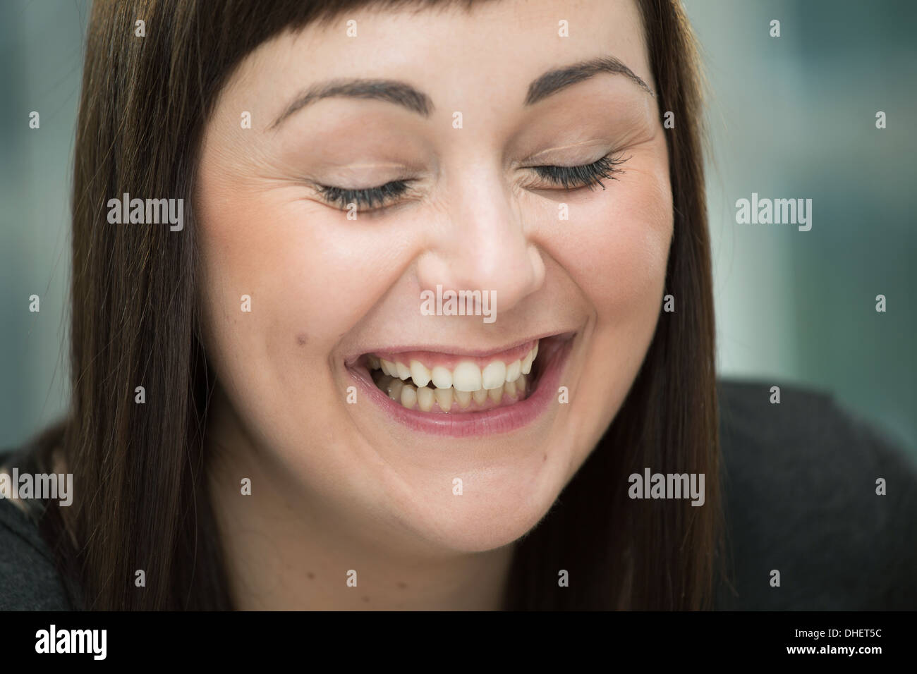 Junge Frau lachen, Augen geschlossen Stockfoto
