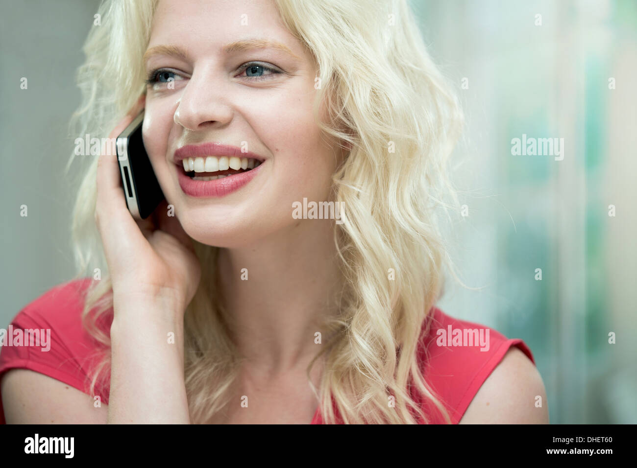 Junge Frau am Handy, Lächeln Stockfoto