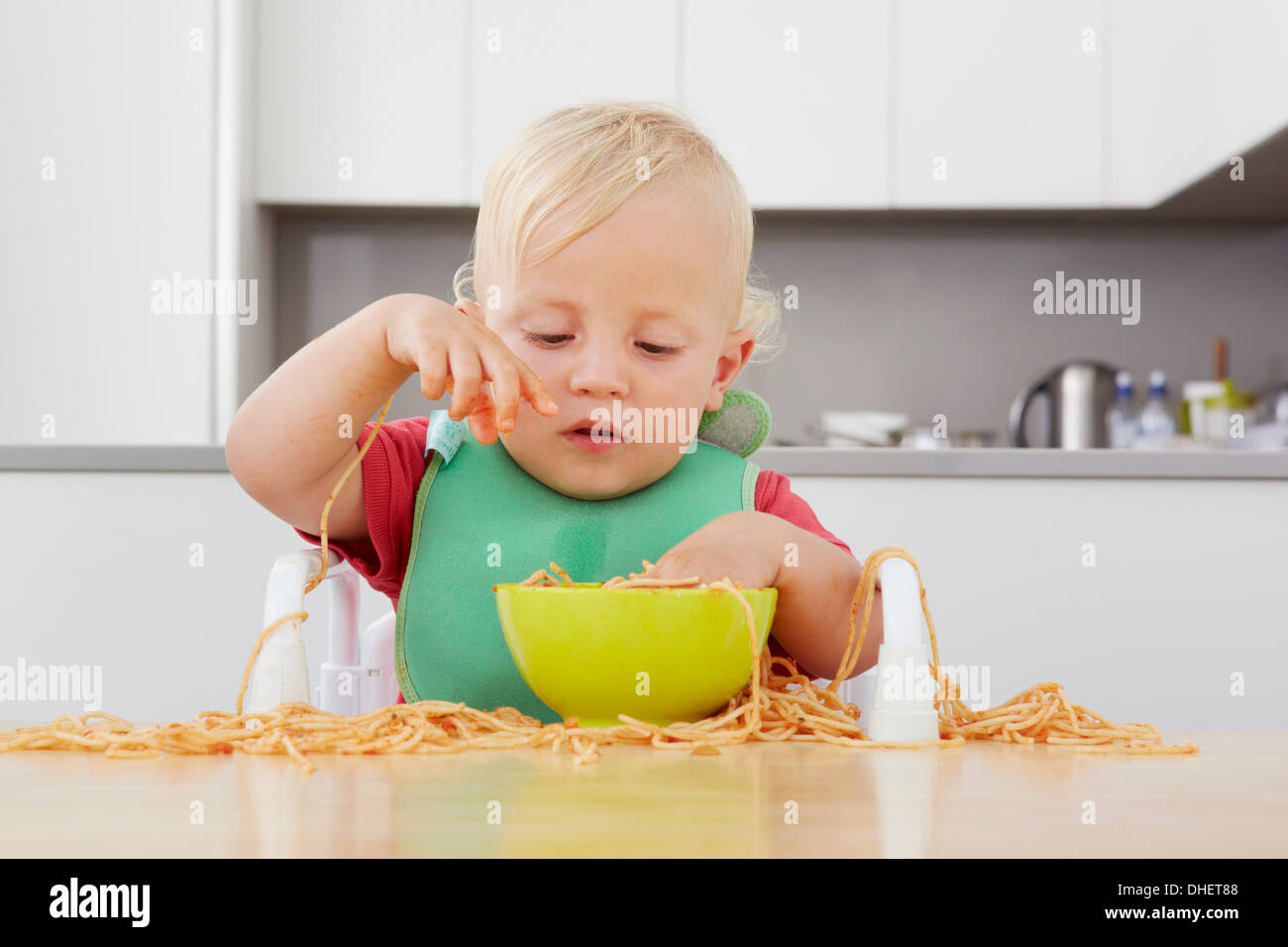 Kleinkind spielt mit spaghetti Stockfoto