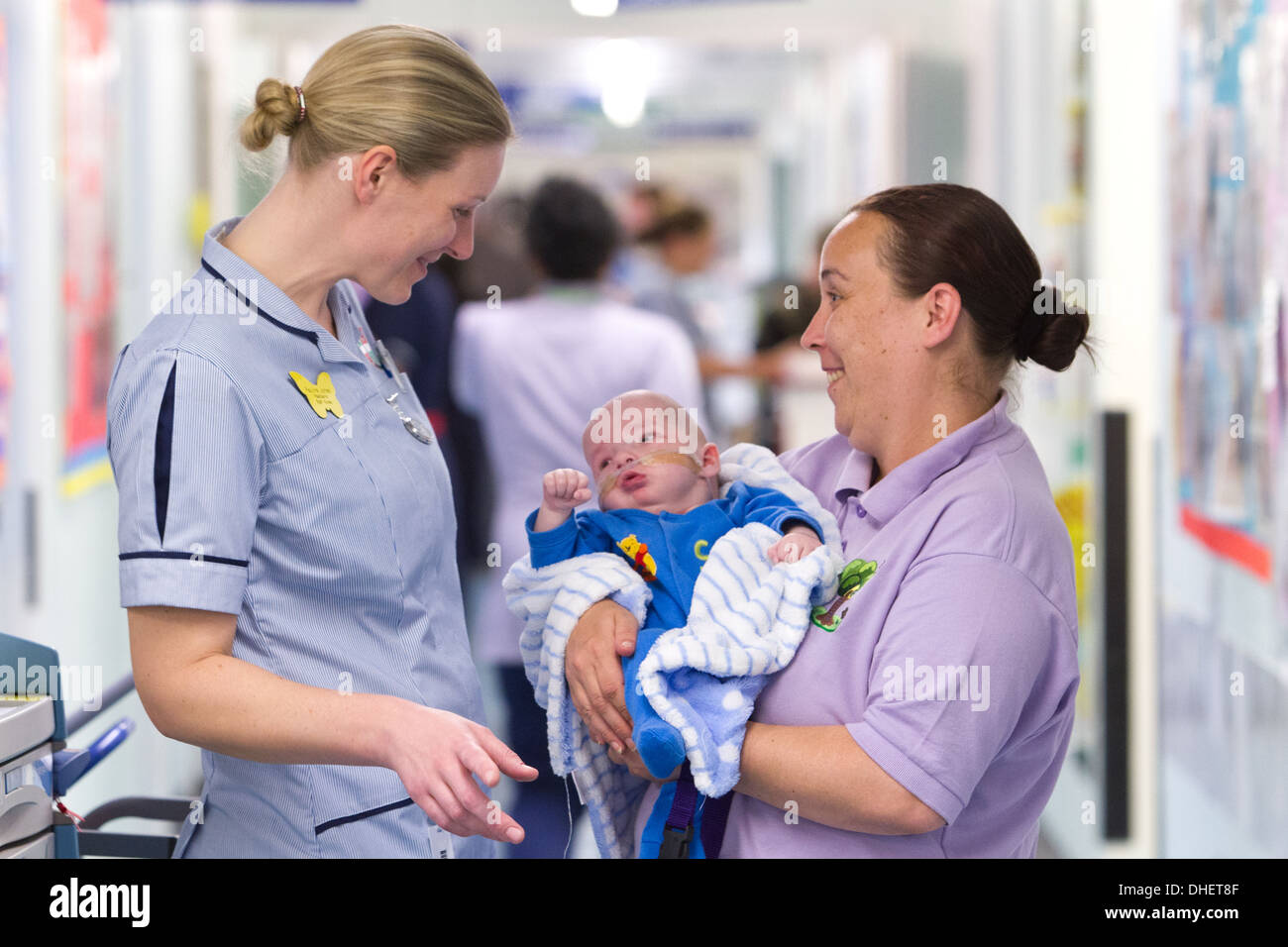 Eine Kinderkrankenschwester und Pflegedienst kümmert sich ein Baby UK Stockfoto
