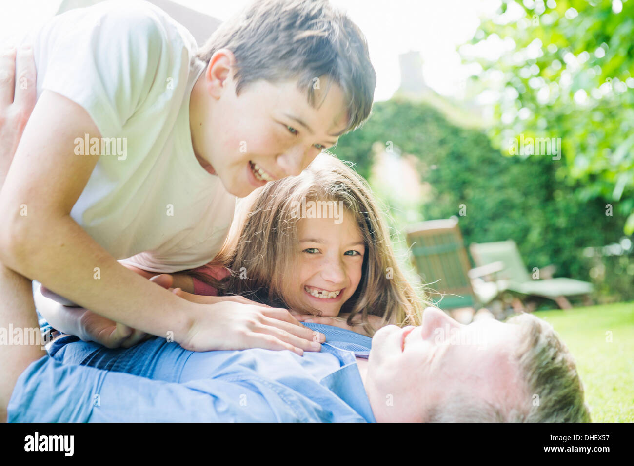 Vater mit Sohn und Tochter spielen im Garten Stockfoto
