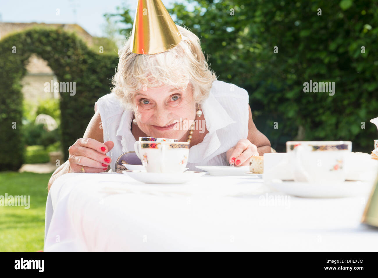 Ältere Frau mit Partyhut Blick in die Kamera, Lächeln Stockfoto