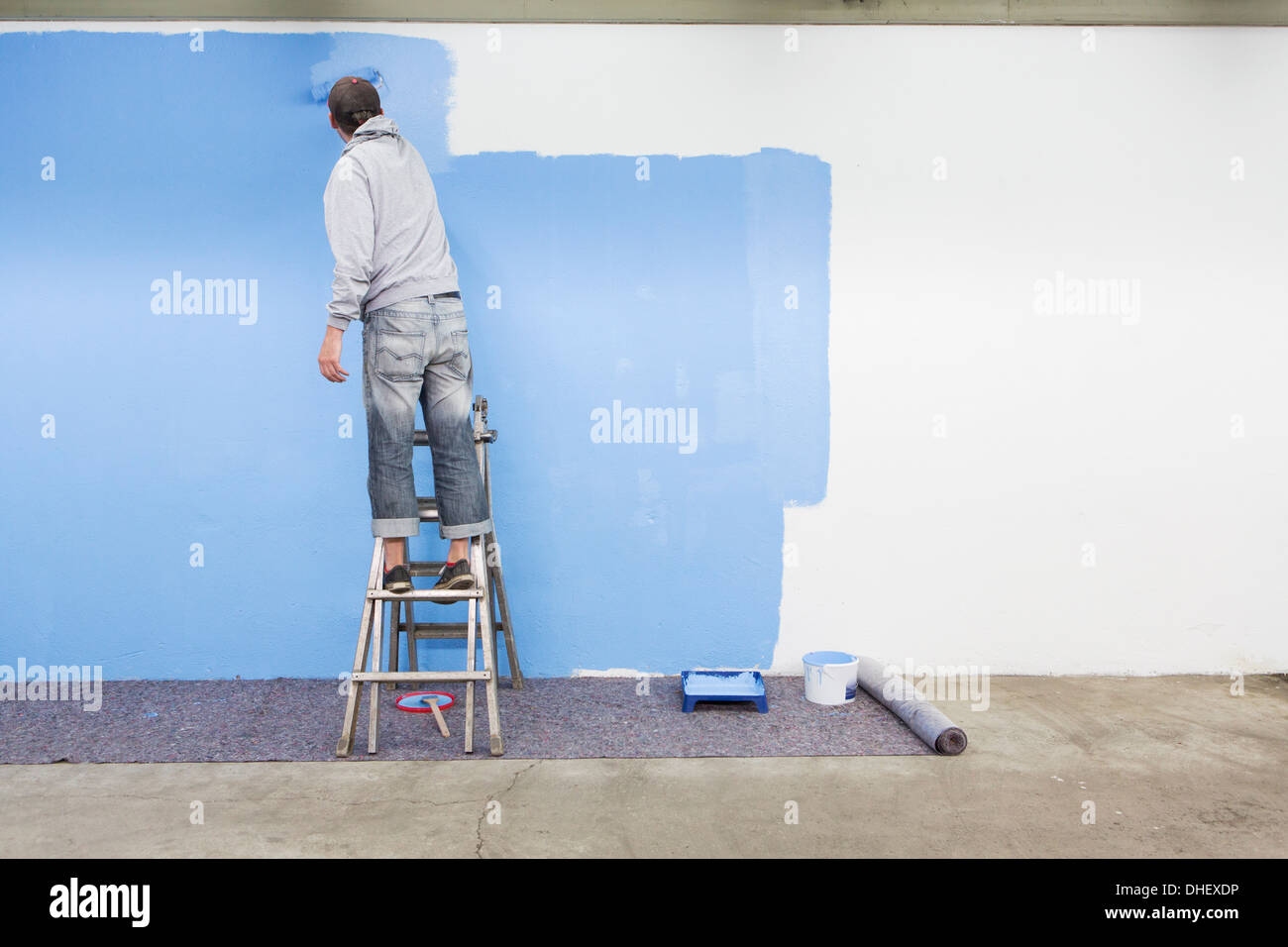 Rückansicht des Mannes Malerei Wand blau Stockfoto