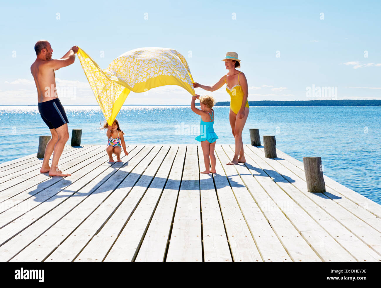 Eltern und zwei junge Mädchen spielen auf Pier, Utvalnas, Hotels, Schweden Stockfoto