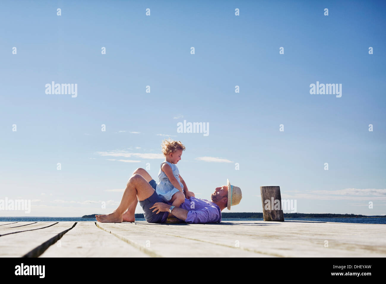 Weibliche Kind und Vater auf Pier, Utvalnas, Hotels, Schweden Stockfoto