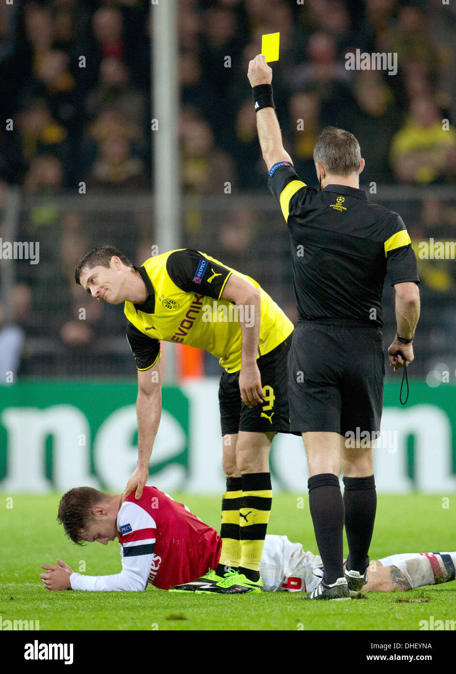 Dortmund, Deutschland. 6. November 2013. Dortmunder Robert Lewandowski (C) zeigt Bjoern Kuipers (R) bei Arsenal Keeper Aaron Ramsey auf dem Boden während der Champions-League-Spiel Borussia Dortmund vs. FC Arsenal London im Signal Iduna Park in Dortmund, Deutschland, 6. November 2013 liegt Schiedsrichter die gelbe Karte. Foto: BERND THISSEN/Dpa/Alamy Live-Nachrichten Stockfoto