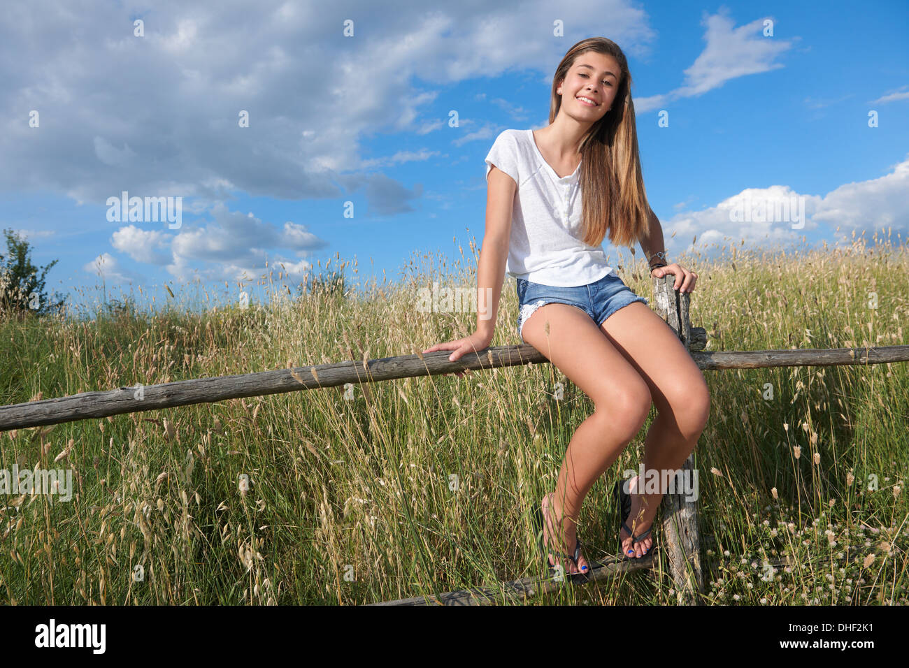 Teenager-Mädchen sitzen auf Holzzaun, Toskana, Italien Stockfoto