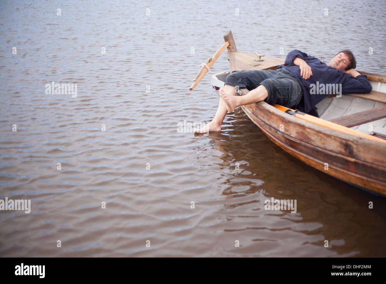 Mann liegt im Ruderboot, Wales, UK Stockfoto