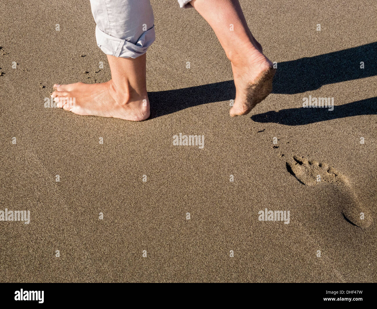 Zu Fuß in den Sand des Strandes Stockfoto