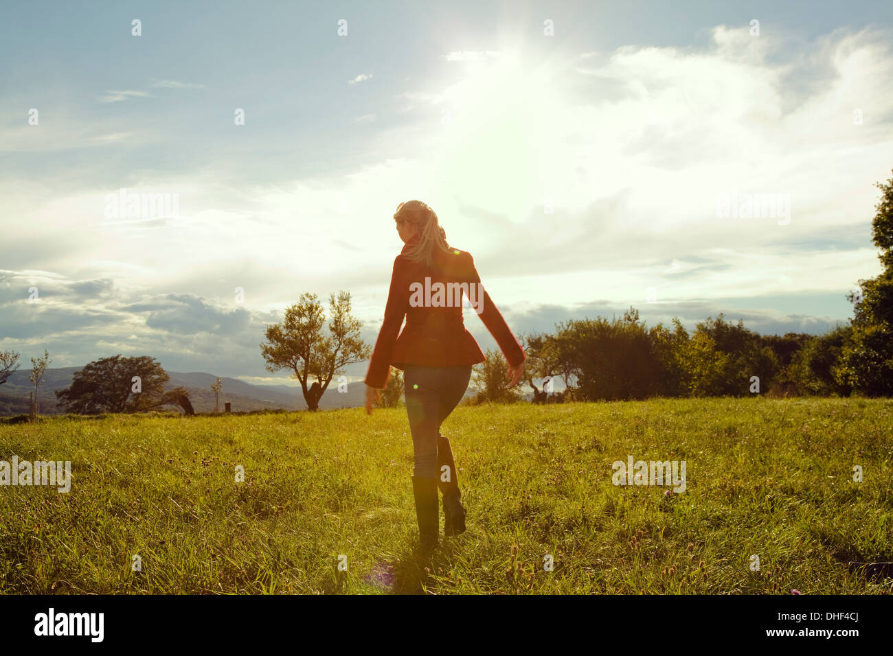 Junge Frau im Feld zu Fuß entfernt Stockfoto