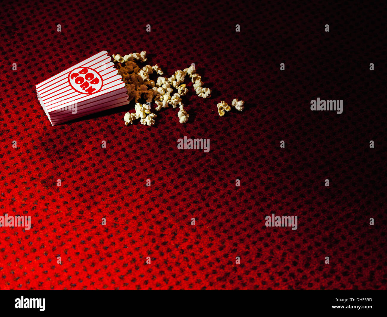 Verschüttete Karton Popcorn auf Kino-Teppich Stockfoto