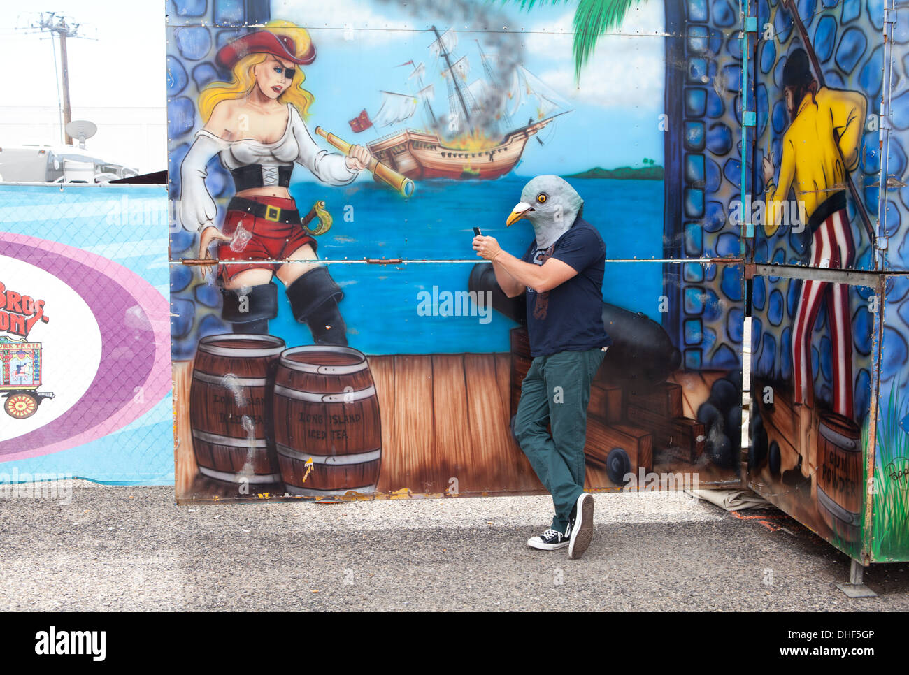 Mann trägt eine Taube Maske prüft seine Smartphone auf einem Jahrmarkt, USA. Stockfoto