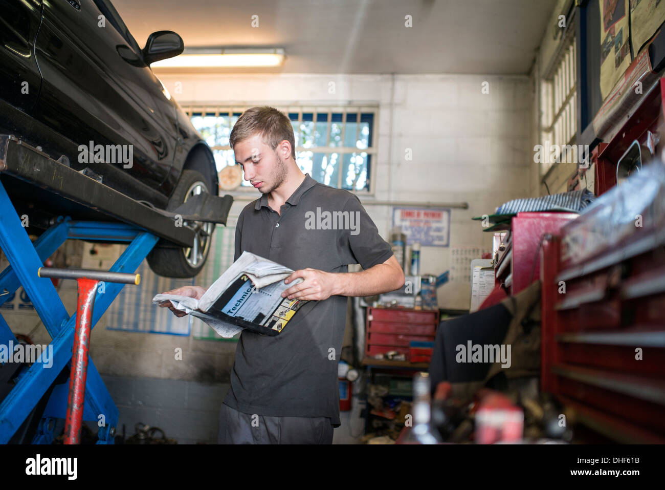Mechaniker lesen Handbuch in garage Stockfoto