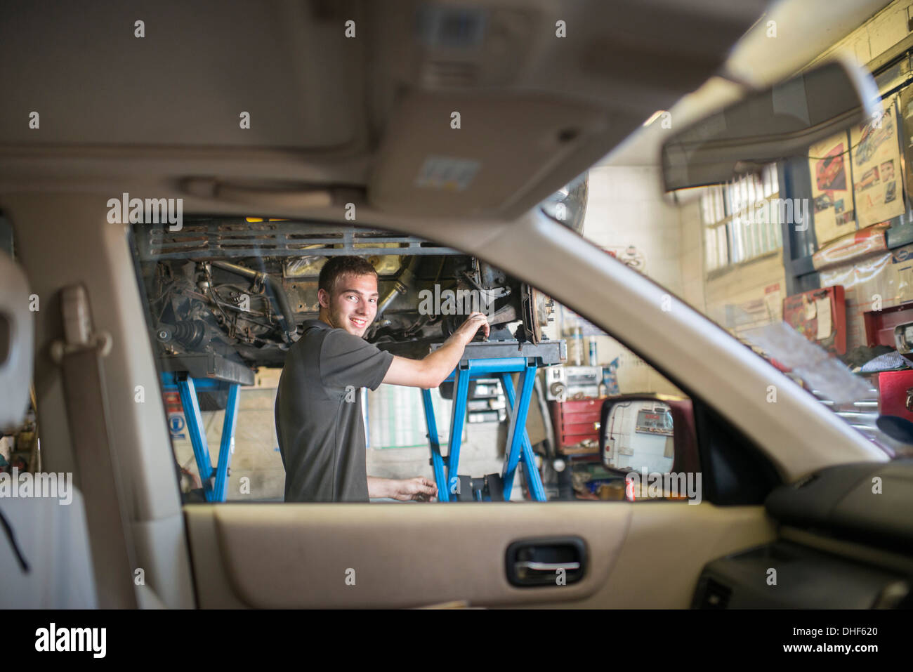 Mechaniker, die lächelnd in Richtung Kamera durch Autofenster Stockfoto