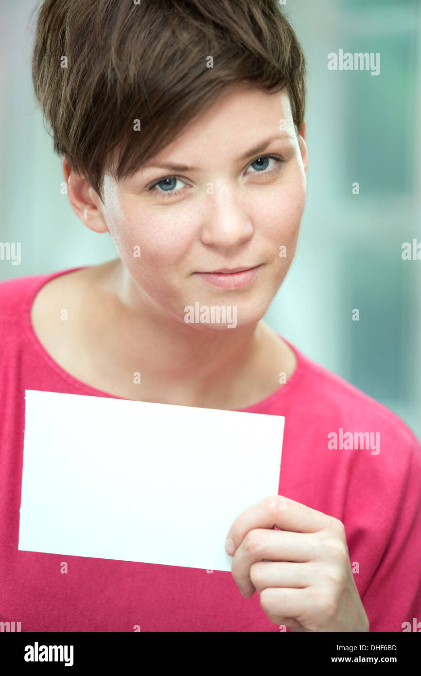 Junge Frau halten weiße Karte Stockfoto