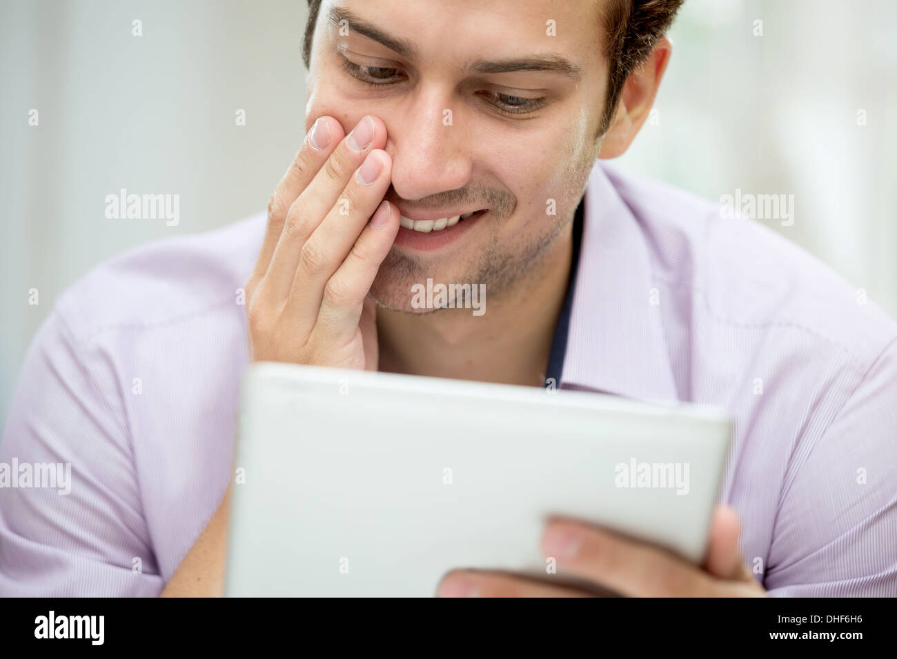 Junger Mann, Blick auf Nachricht auf digital-Tablette Stockfoto