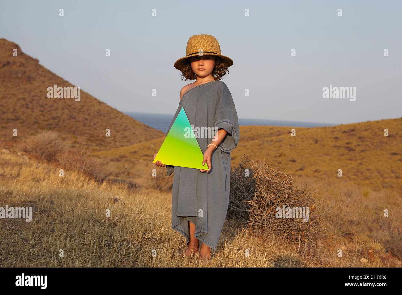 Porträt von Mädchen hält Dreiecksform in Feld Stockfoto