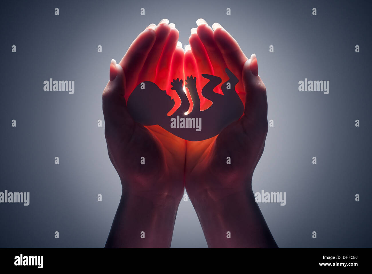 Embryo-Silhouette in der Hand der Frau Stockfoto