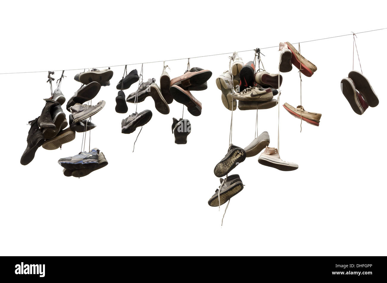 Schuhe und Sneakers an Seilen über der Straße. Isoliert Stockfoto