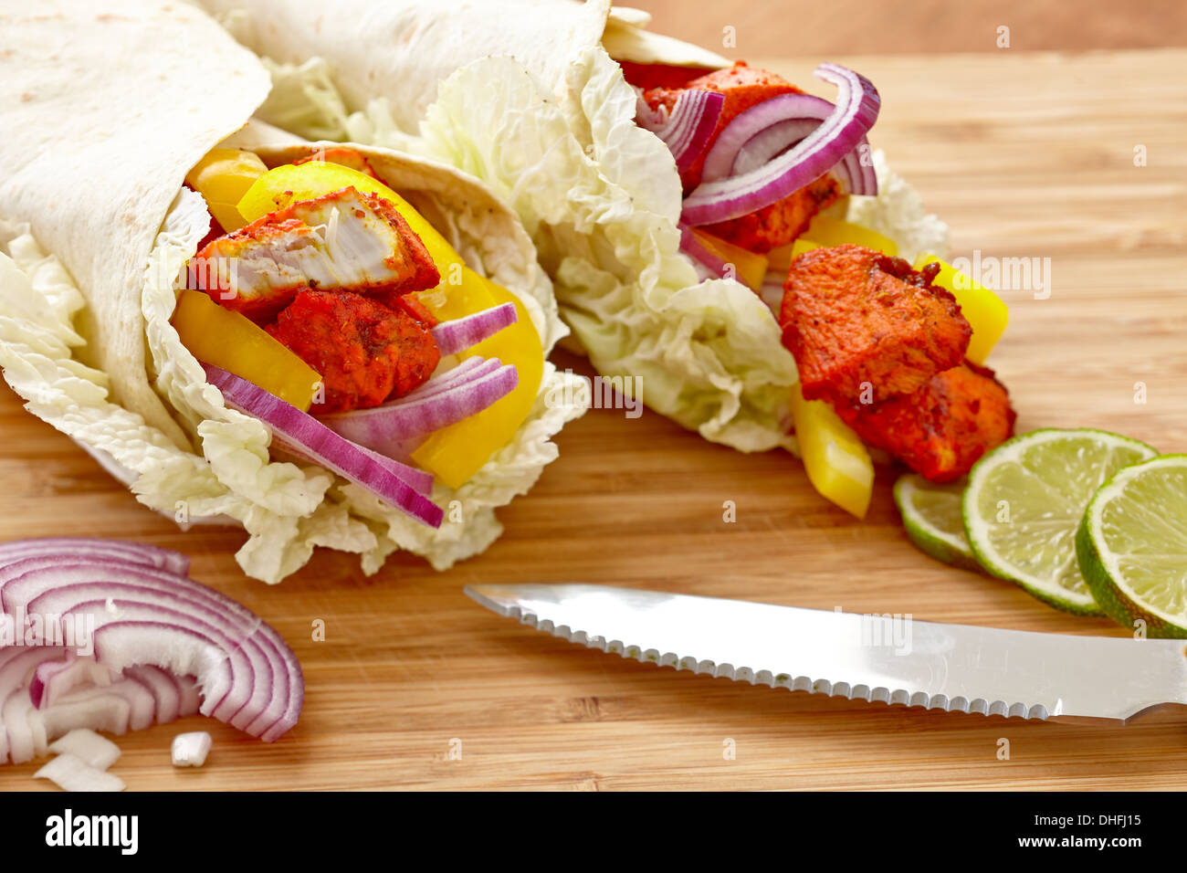 Tandoori Masala gewürzt Tortilla wraps mit Salat, Zwiebel, Paprika und Kalk Stockfoto