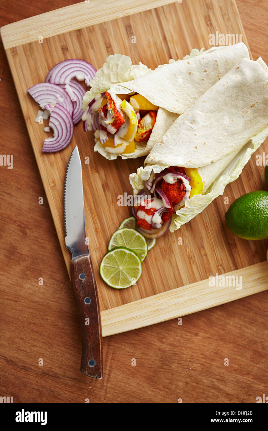 Tandoori Masala gewürzt Tortilla wraps mit Salat, Zwiebel, Paprika und Kalk Stockfoto