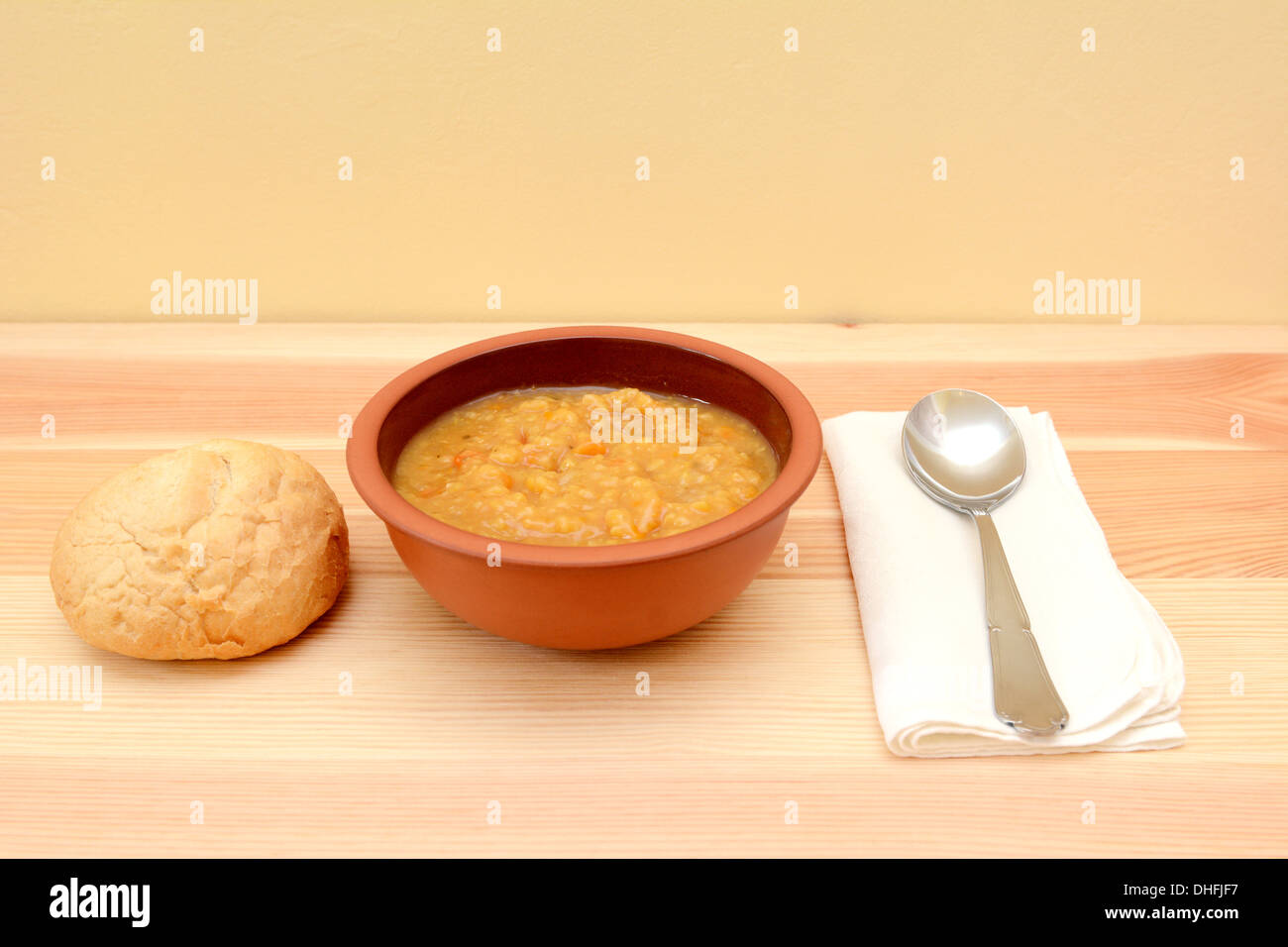 Suppe in eine Schüssel mit knusprigem Brot Roll, Löffel und Leinen-Serviette Stockfoto