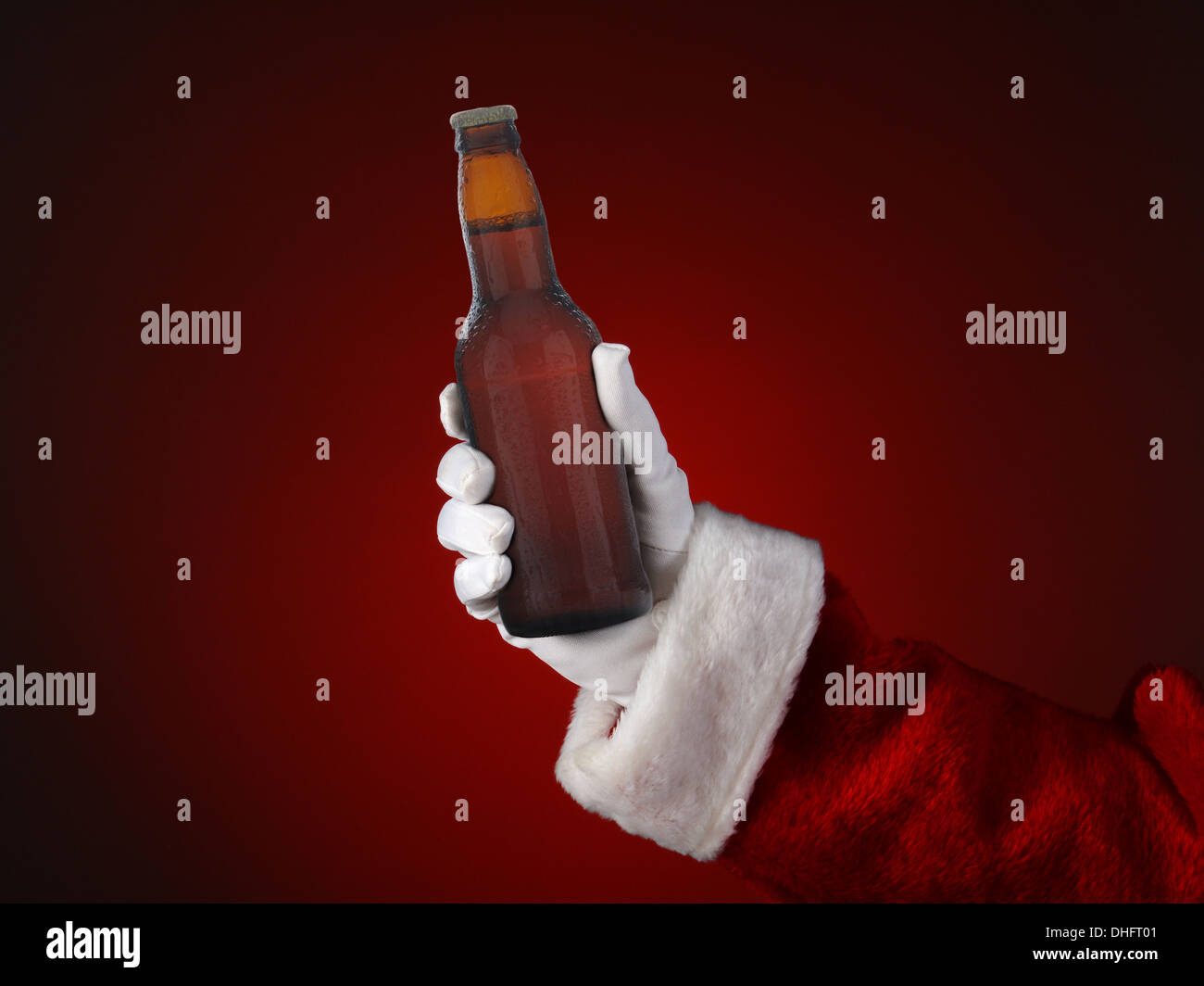 Nahaufnahme von Santa Claus mit einer Flasche Bier. Nur Hand- und Armbewegungen sind sichtbar. Stockfoto