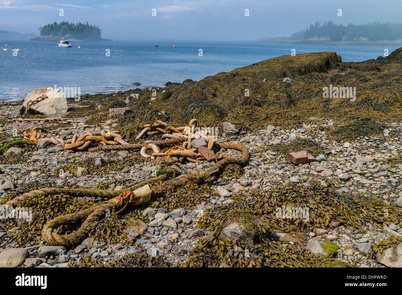 Eine Ankerkette befestigt an einem großen Felsbrocken liegt auf einem auf felsigen Küstenstreifen an Lubec Maine. Stockfoto