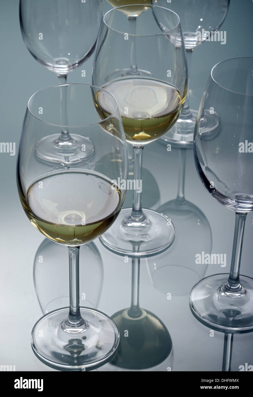 Weißweingläser zusammen mit anderen leere Gläser auf einem Glastisch Stockfoto