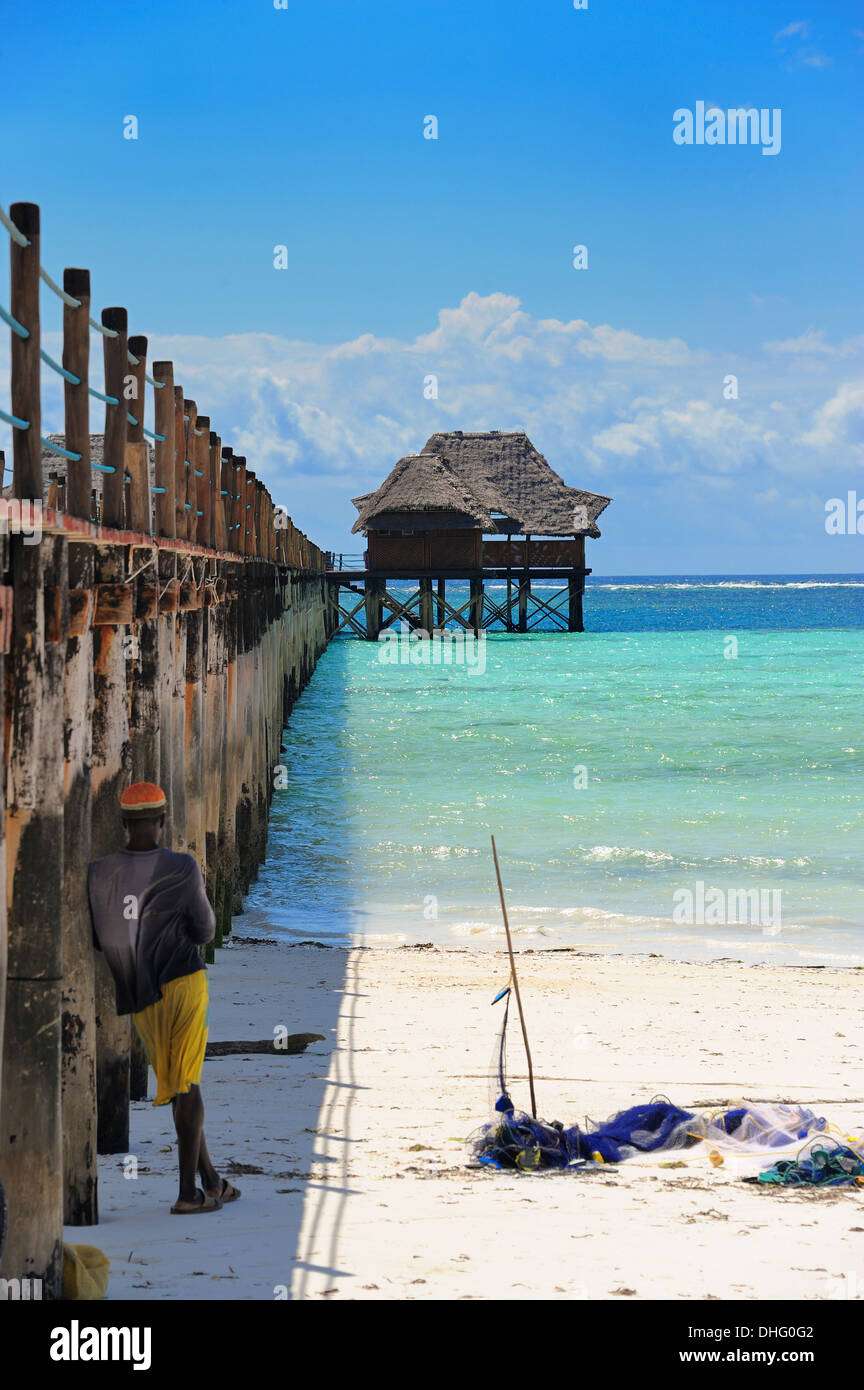 Mann Angeln neben einem Hotel Steg, Bwejuu Strand, Indischer Ozean, Sansibar, Tansania, Ostafrika Stockfoto