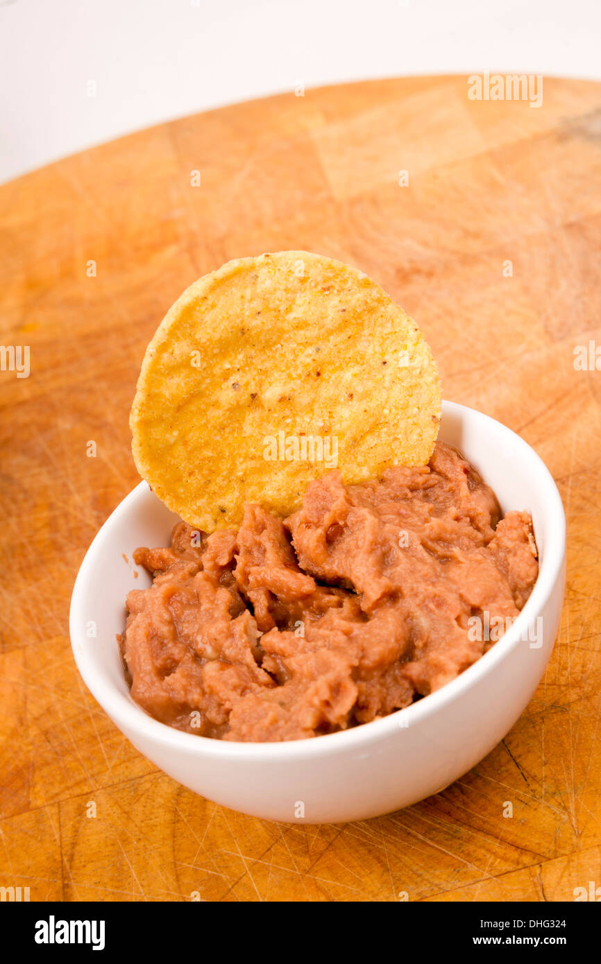 Ein Mais-Chips in gebackenen Bohnen in Keramik Töpfchen getaucht Stockfoto