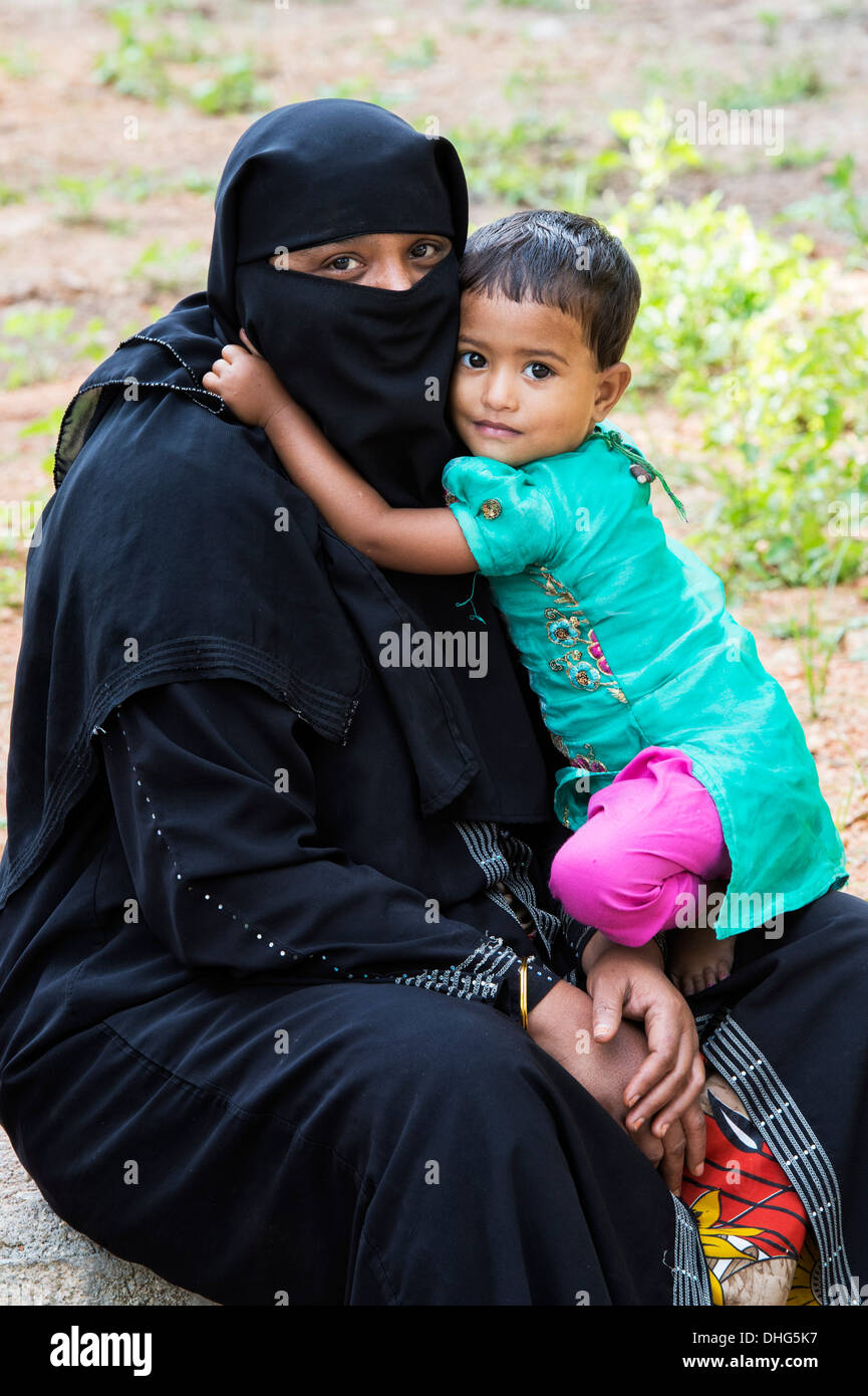 Indisches muslimische Kleinkindes Mädchen umarmt ihre Mutter. Andhra Pradesh, Indien Stockfoto